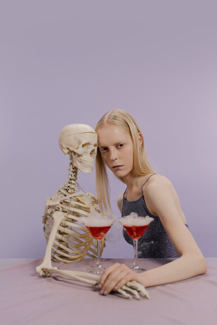 woman in gray tank top leaning her head on a skeleton