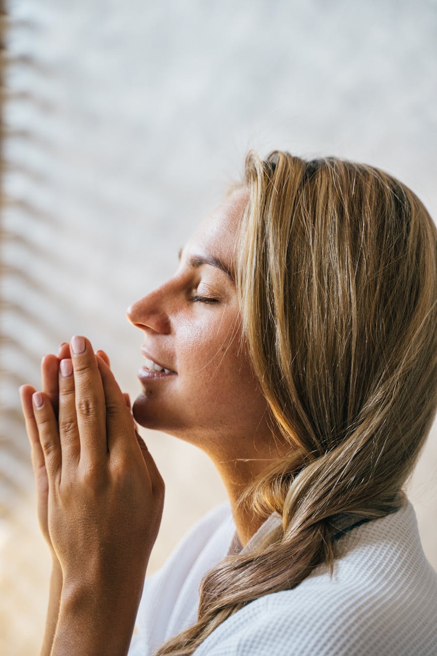 woman in wearing white robe praying