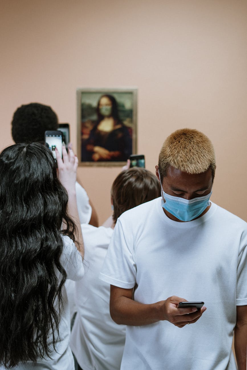 group of people looking at a painting of mona lisa with face mask