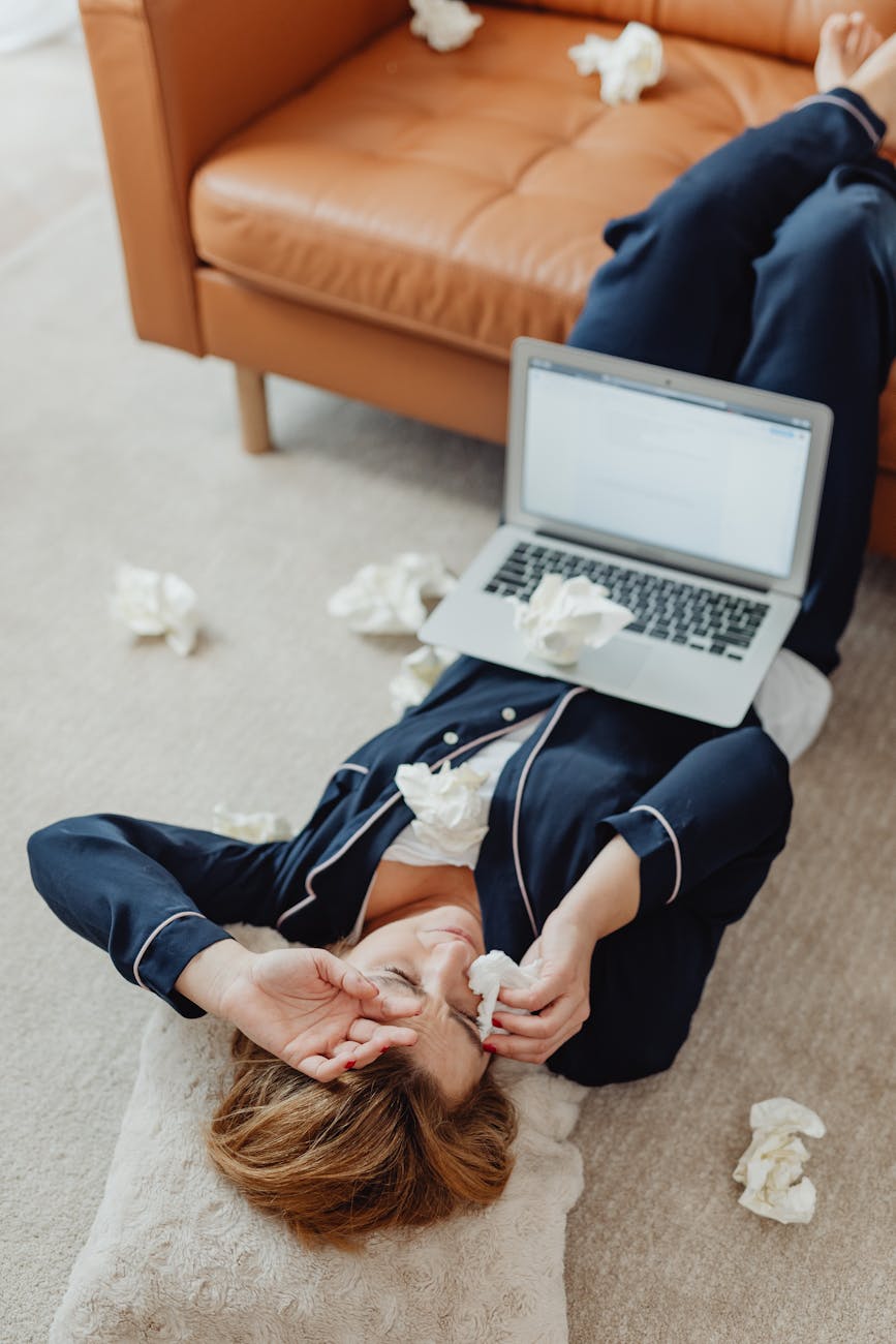 woman crying on the floor with a laptop on her stomach